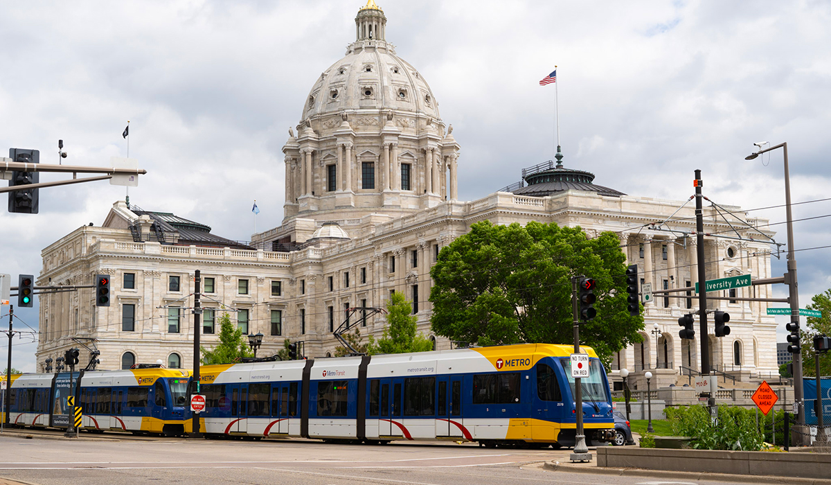 A photo of the Minnesota State Capitol building with a METRO light rail train outside.