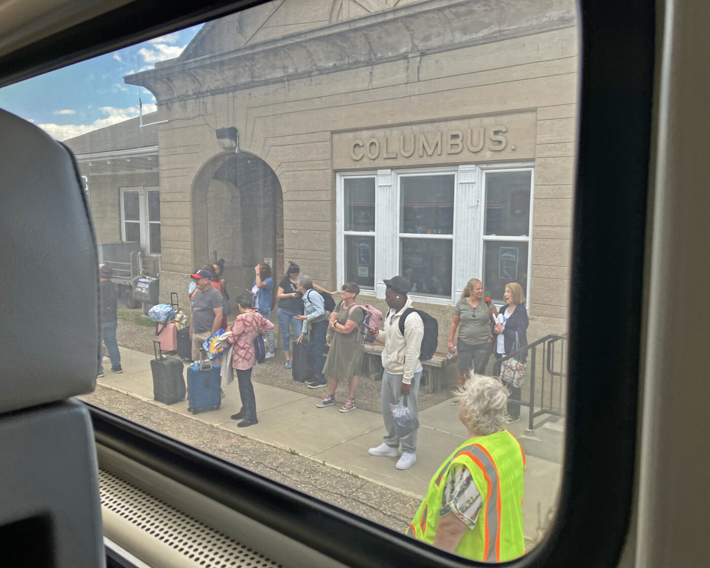 A station in Columbus with a number of passengers waiting, some with large suitcases