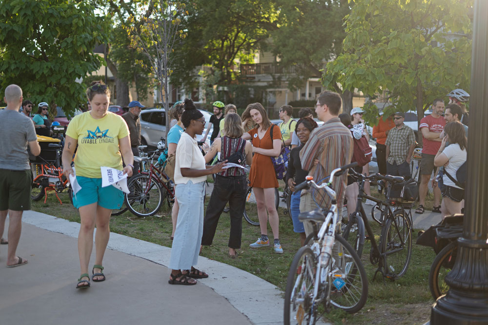 A group of advocates mingle and chat at Painter Park before the start of a rally  