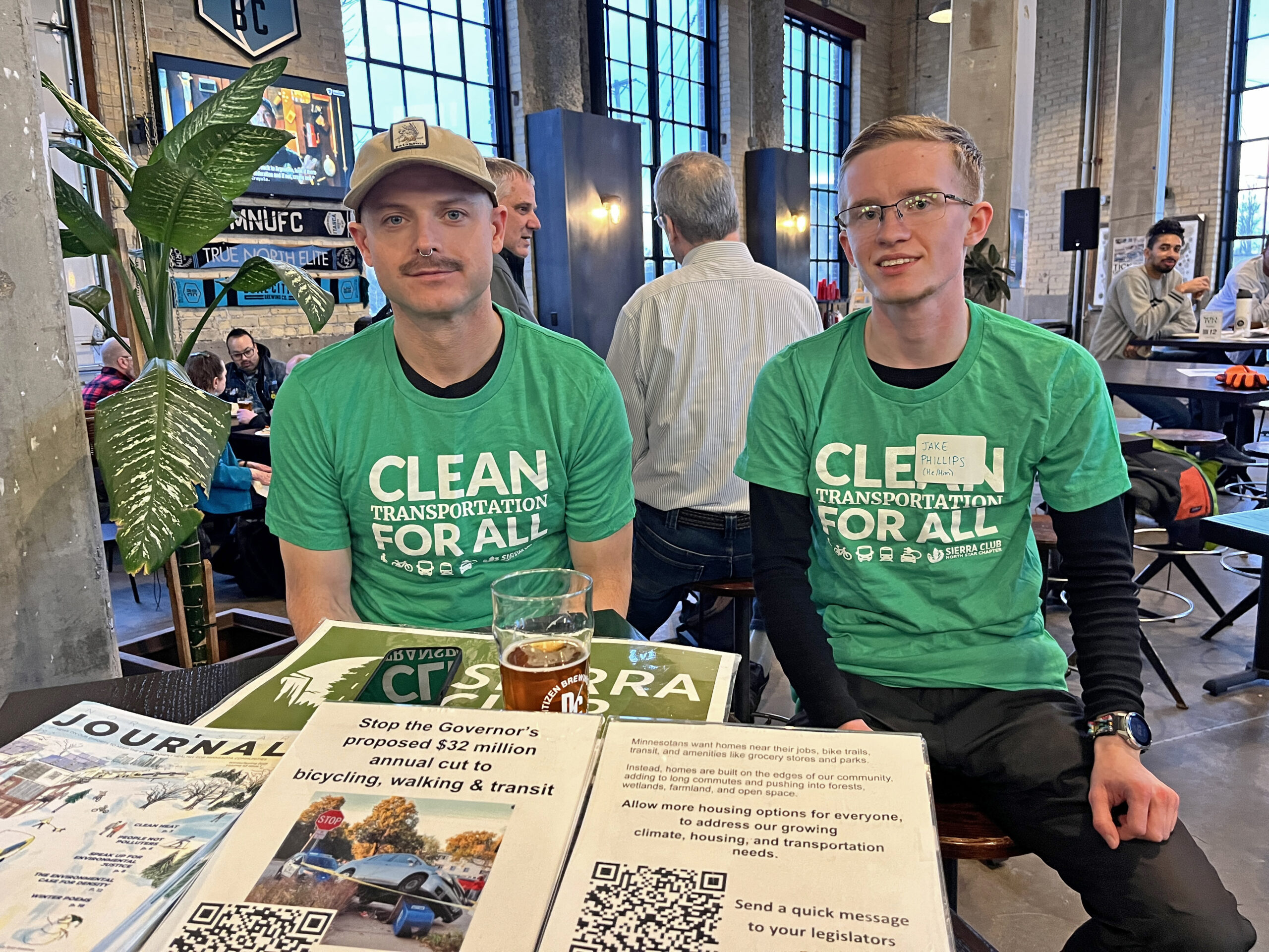 Two young male volunteers from Sierra Club wearing matching green tshirts that say Clean Transportation for All